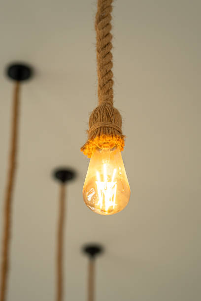 istock Rope ceiling lighting bulb, glowing in warmlight shade. 2157700225