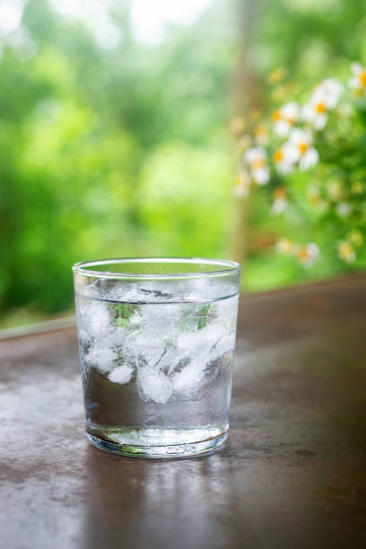istock a glass of cold water with ice on rustic table. 2157700446