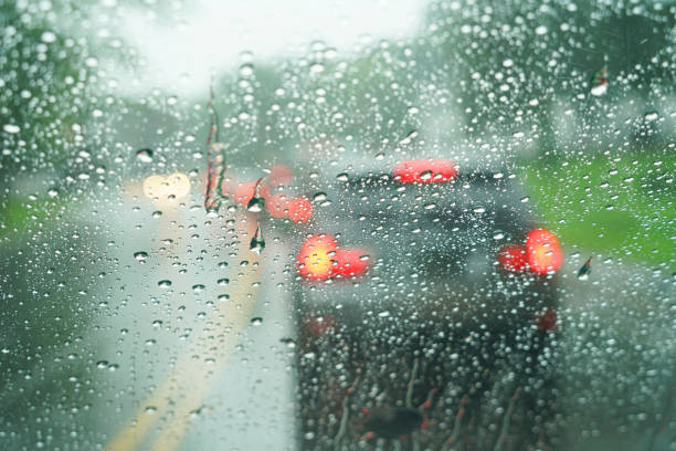 istock blurred street scene through car windows with rain drop 2157702207