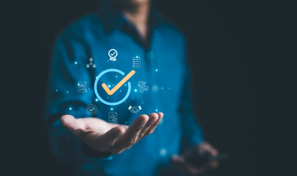istock Businessman holding a digital icon of a checkmark with quality assurance and certification symbols, standard compliance and guarantee. quality control, automation process, Standardization management, 2157704146