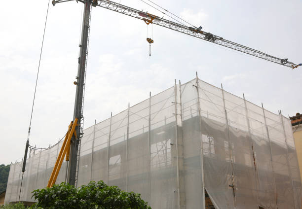 Construction site during the building of a structure with scaffolding and a crane to lift heavy loads without people