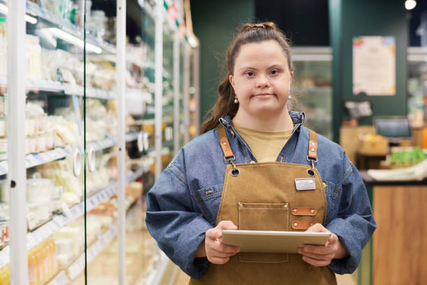 istock Girl with Disability Working in Supermarket Holding Tablet 2157705981