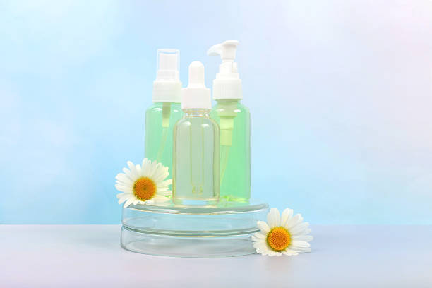 istock Bottles with lotion with chamomile extracts and flowers on a light background, the concept of natural organic cosmetics, advertising for spa and store, minimal composition.. 2157707576