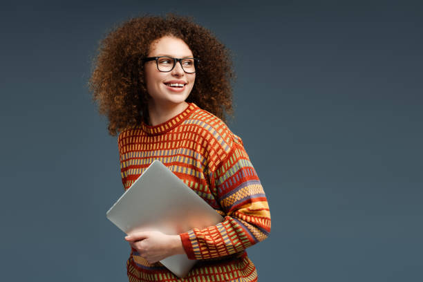 Portrait of smiling woman, freelancer using laptop holding computer looking away