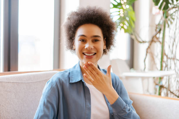 istock Cheerful, authentic, smiling African American woman with curly hair communicates using sign language 2157709208