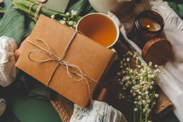 istock Gift box with a bow in hands in a homely atmosphere 2157709569