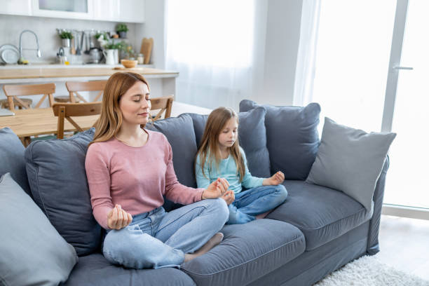 istock Peaceful mom and child meditating on living room sofa 2157710961