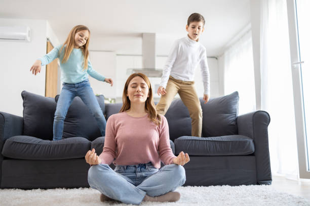 istock Mother in meditation with kids playing around 2157710992