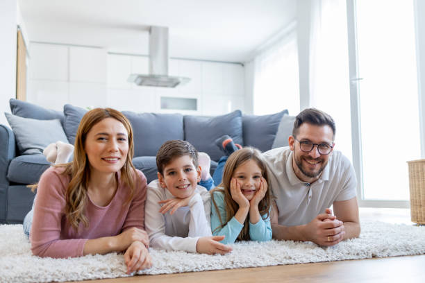 istock Relaxed family lying on home floor looking up 2157710993