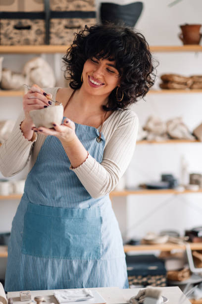 istock Happy female potter at pottery studio doing clay work with pottery tool 2157711290