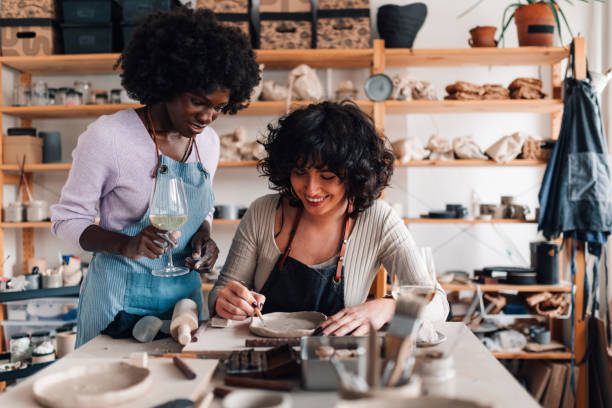 istock Happy diverse pottery course attendees doing clay work and drinking wine 2157711300