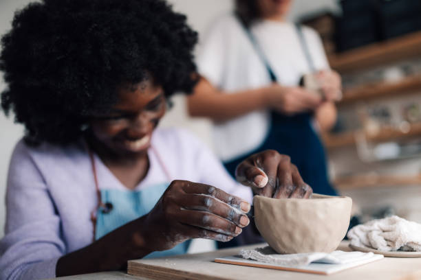 Close up of diverse pottery class student learning clay modeling.