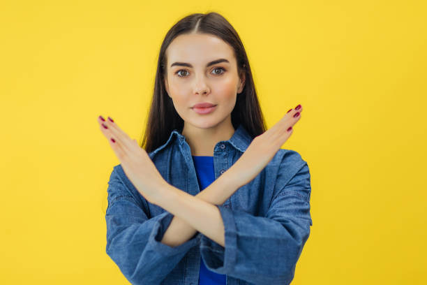 istock young woman with serious facial expression crossing hands for showing stop gesture. refusing with sign of prohibition. 2157711865