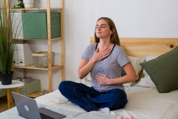 istock Young woman practicing mindfulness meditation with online tutor 2157713855