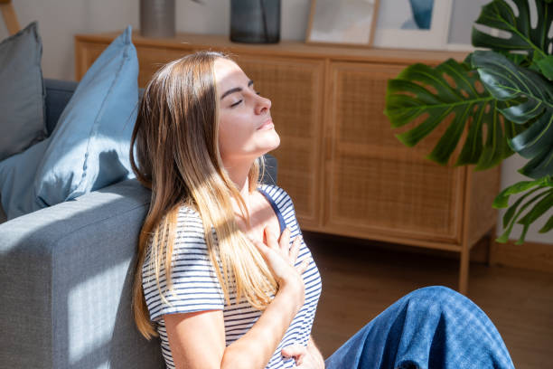 Young woman practicing mindfulness breathing exercise at home