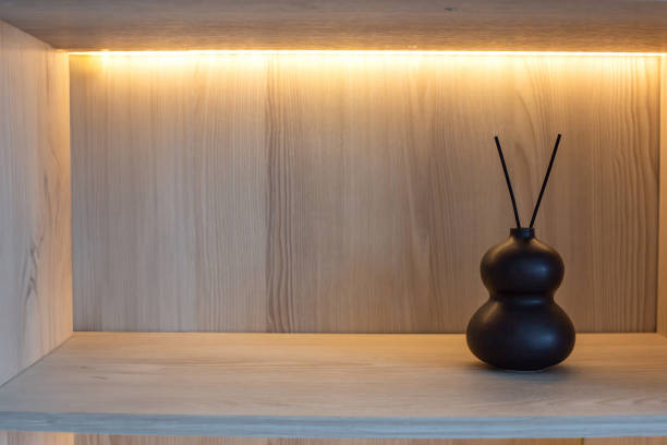 istock On a wooden shelf with warm lighting there is a small black ceramic vase with two sticks of incense 2157714833
