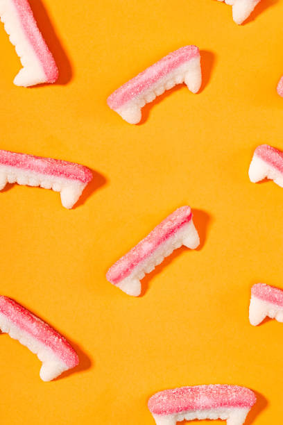 istock Creative Halloween background with gummy vampire teeth candy on bright orange background 2157715799