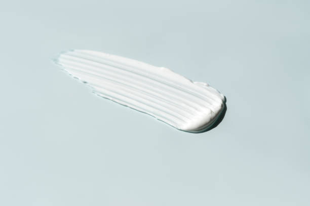 istock White cosmetic cream smear blue background 2157716343