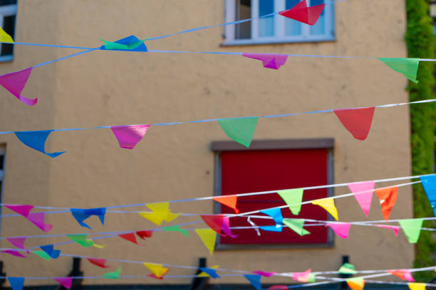 a colorful banner with many different colored flags hanging from a building