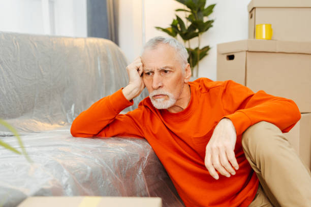 istock Upset tired mature man sitting on floor feeling exhausted preparing unpacking cardboard boxes 2157719158