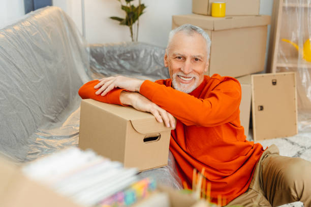 istock Happy smiling senior man looking at camera and relaxing while unpacking cupboard boxes 2157719190