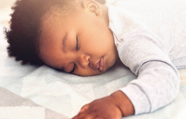 istock Baby, african and boy sleeping on bed for rest, health and peace for growth, development and relax in family home. Black male infant, tired and sleep in bedroom with fatigue, quiet and calm in house 2157719921