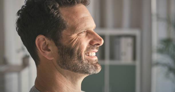 istock Home, thinking and man with wonder, happiness or decision with peace, ideas or thoughts in lounge. Cheerful, apartment or guy with smile, calm or relax with weekend break or morning with start of day 2157720614