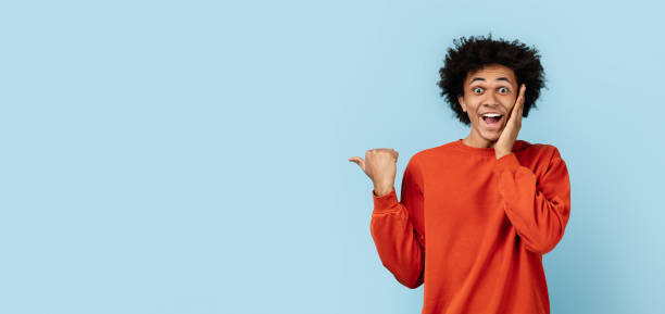 istock Excited black guy pointing with thumb on blue background 2157720957