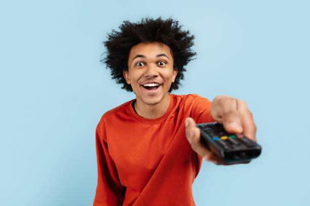 istock Excited black man with TV remote control 2157720970
