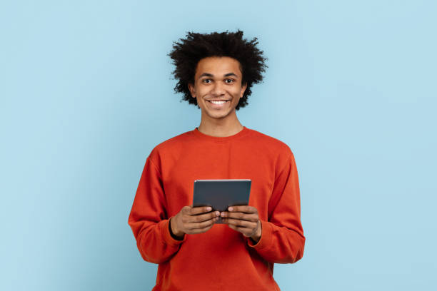 istock Casual man holding digital tablet on blue background 2157720985