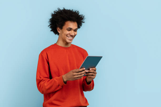 istock Man engaged with digital tablet on blue background 2157720999