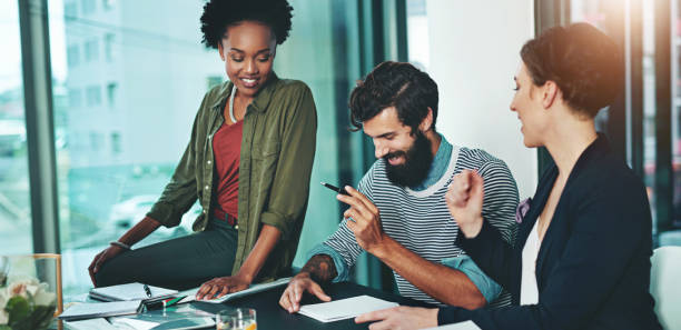 istock Business people, meeting and teamwork with paperwork for employee training and brainstorming in office. Designer group, communication and collaboration with documents for intern feedback and support 2157721946