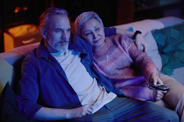 istock Senior Couple Watching Movie on Sofa 2157722281