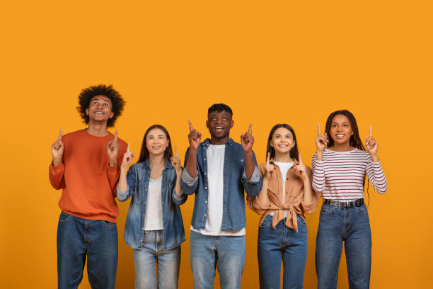 istock Diverse group of people pointing up on orange background 2157722358