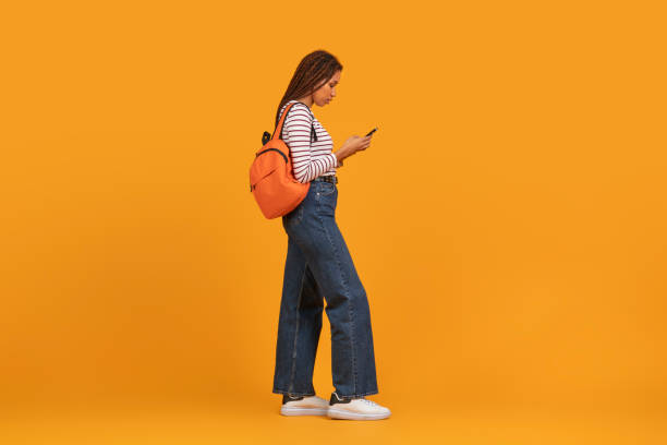 istock Stylish woman walking with phone and backpack 2157722396