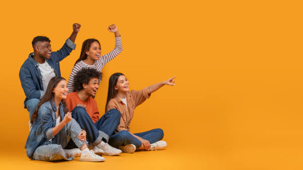 istock Joyful friends cheering and pointing to the side 2157722422