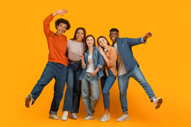 istock Happy friends hugging and smiling on orange background 2157722452