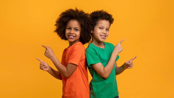 istock Two Young Children Standing Together, Pointing Aside 2157722656