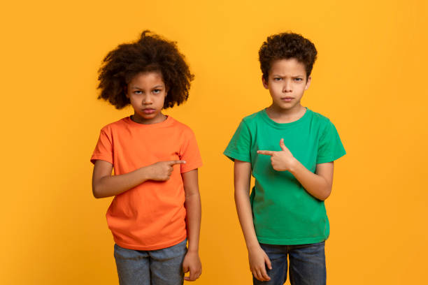 istock Two Young Siblings Pointing at Each Other With Confused Expressions 2157723160