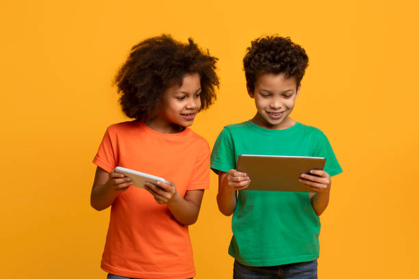 istock Two Young Children Standing Looking at a Tablet 2157723167