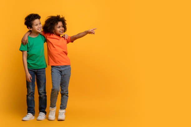 istock Two Joyful Children Pointing and Looking at Copy Space 2157723189