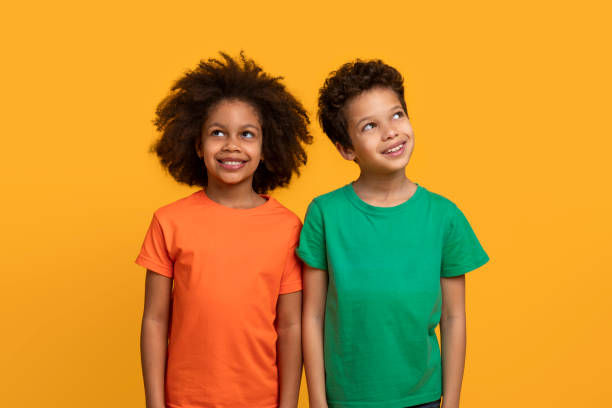 istock Two Children in Bright Colored T-Shirts Against Orange Background 2157723204