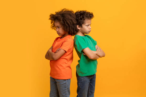 istock Two Young Boys Standing Back to Back With Arms Crossed 2157723217