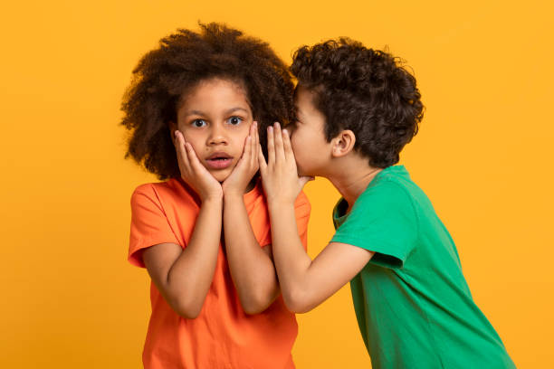 istock Young Boy Whispering a Secret to His Surprised Sister 2157723220