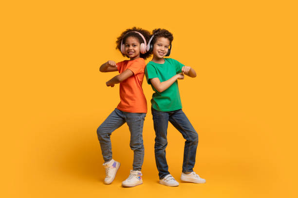 istock Two Children Dancing on a Yellow Background 2157723244