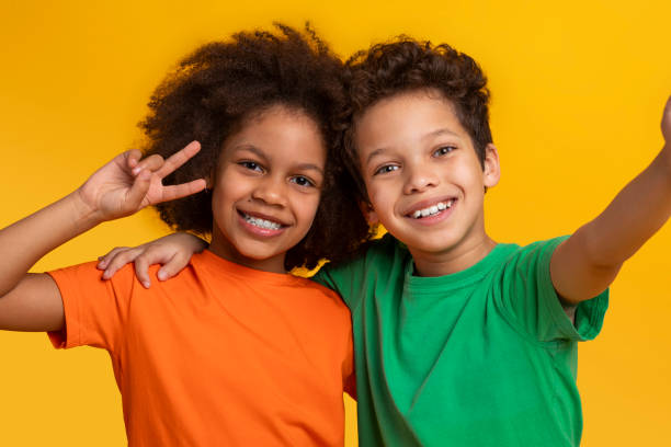 istock Joyful children posing with peace signs, take selfie 2157723279
