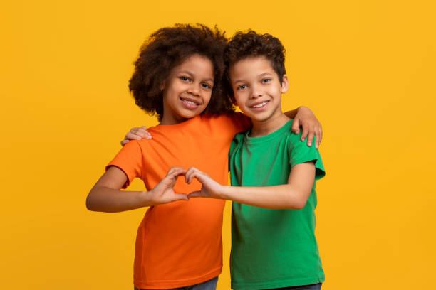 istock Kids making heart shape with hands on yellow background 2157723293