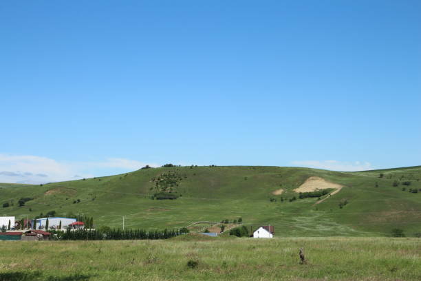 istock A grassy hill with buildings and trees 2157723382
