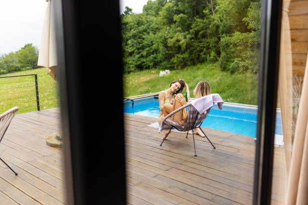 istock Two beautiful women having relaxing time by the pool in countryside 2157724264