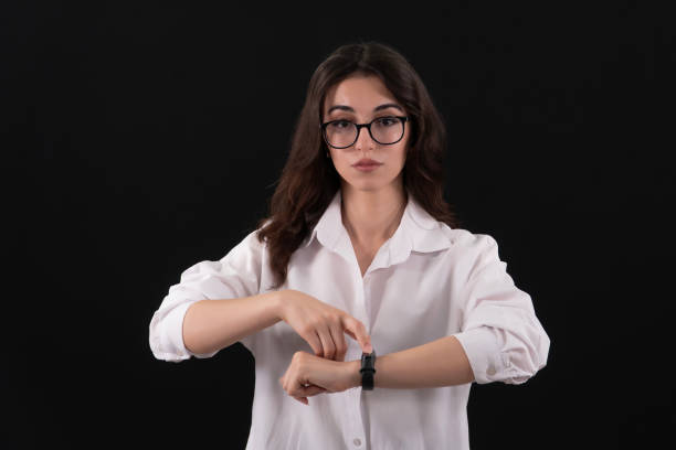 A Business people using smartwatch while working at the office. Close up of Hands of Businesswoman using Smartwatch. Black background.